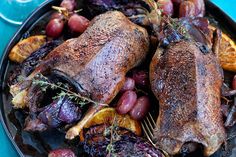 a plate with some meat and grapes on it