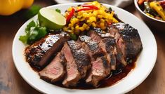 a white plate topped with meat and veggies next to a bowl of rice