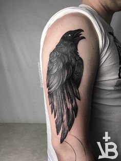 a man with a black crow tattoo on his arm