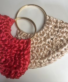 two pieces of fabric with gold rings on top of each other, one red and one beige