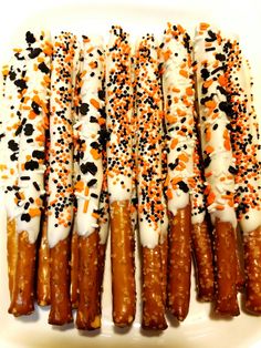 several pretzels with sprinkles and white frosting on a plate