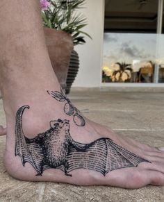 a person with a bat tattoo on their foot