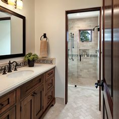 a bathroom with a sink, mirror and shower stall in the middle of it's room