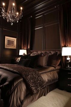 a large bed sitting under a chandelier next to two nightstands in a bedroom