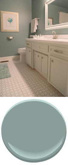 a bathroom with blue walls and white cabinets in the same color as the rest of the room