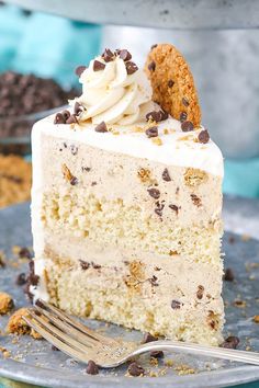 a piece of cake with white frosting and chocolate chips