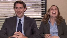 a man and woman laughing while sitting in front of a window with blinds on the windowsill