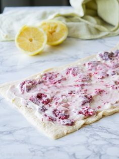 a flat bread with cranberry sauce and lemons on the table next to it