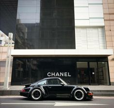 a black car parked in front of a building with the word chanel on it