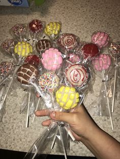 a hand holding a bunch of candy lollipops