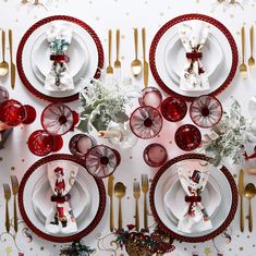 a christmas table setting with red and white plates