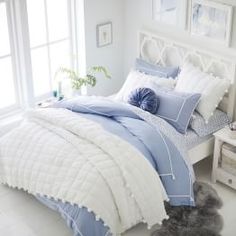 a bed with blue and white comforters in a bedroom