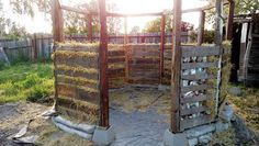 an outhouse with hay in the yard