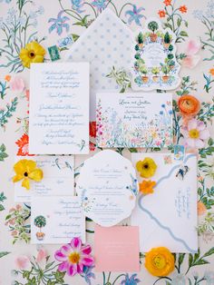 the wedding stationery is laid out with flowers