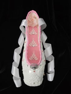 a pair of white ballet shoes with pink and white flowers on them, sitting on a black background