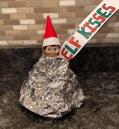 an elf is holding a sign in tin foil