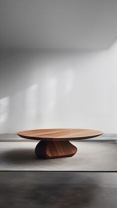 an oval wooden table in the middle of a room with white walls and flooring