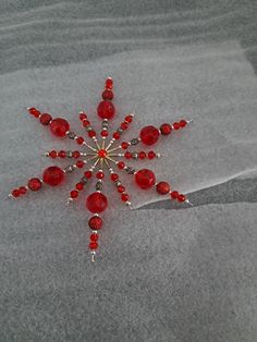 a snowflake made out of red glass beads