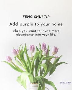 a vase filled with pink tulips sitting on top of a table next to a white wall