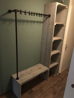 a coat rack and bench in a room with green walls, wood flooring and wooden floors