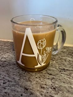 a coffee mug with the letter a on it sitting on top of a granite counter