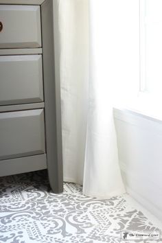 a bathroom with a sink, toilet and white curtains in it's corner next to a window