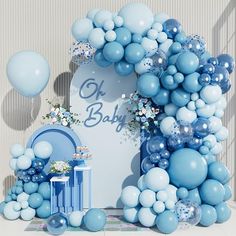 a baby shower with blue and white balloons in the shape of an arch, flowers and gifts