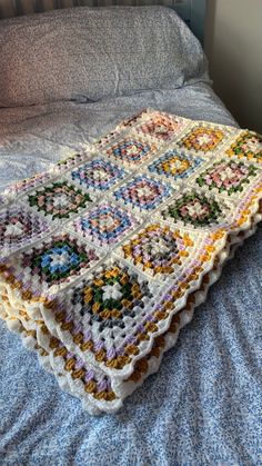 a crocheted blanket sitting on top of a bed