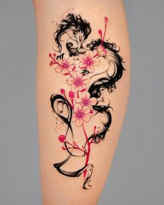 a woman's thigh with flowers and a dragon tattoo on the side of her leg