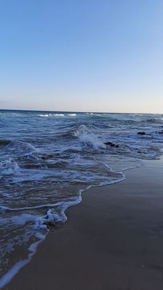 the ocean waves are rolling in to shore