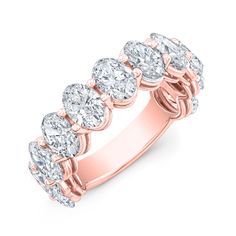 a rose gold ring with five pear shaped diamonds on the side and an oval band