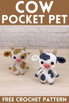 two small crocheted cows sitting next to each other on top of a table