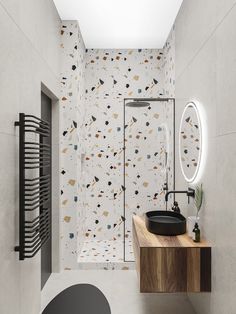 a bathroom with a black sink and white wallpaper on the walls, along with a round mirror