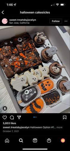 an open box filled with lots of halloween cupcakes on top of a table