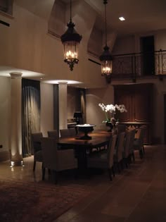 an elegant dining room with chandelier and table surrounded by chairs in the center