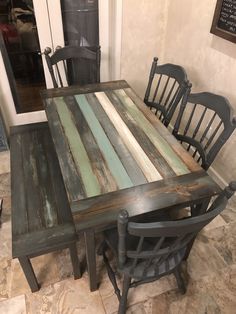 a dining table made out of old wooden planks and painted with different shades of blue