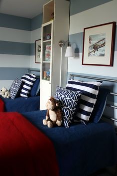 two beds in a room with blue and white striped walls