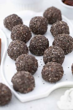 chocolate truffles on a white tray with dipping sauces in small bowls next to them