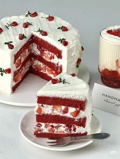 a red velvet cake with white frosting and strawberries on top, cut into slices