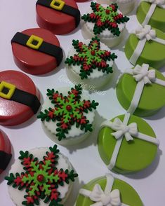 decorated christmas cupcakes with santa hats and snowflakes are on a table