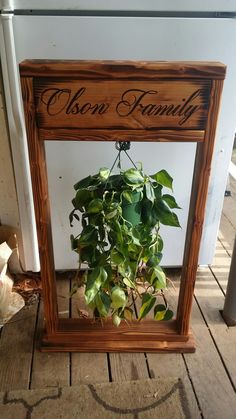 a potted plant in a wooden frame with the word oscar family written on it