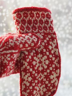 a red and white knitted tie hanging from a window