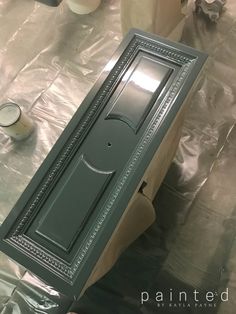 the door is being painted green and ready to be put into the cabinet for painting