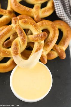 some pretzels are on a black plate with dipping sauce