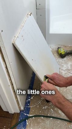 a man is working on the side of a white door with tools in it and an ad that reads, the little ones