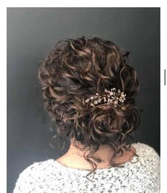 the back of a woman's head wearing a hair comb with flowers on it