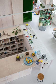 an overhead view of a kitchen with bookshelves and plates on the counter top