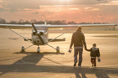 a man and child walking towards an airplane