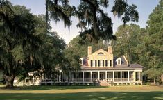 a large white house surrounded by trees and grass