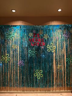 an artistic wall with flowers and ribbons on it